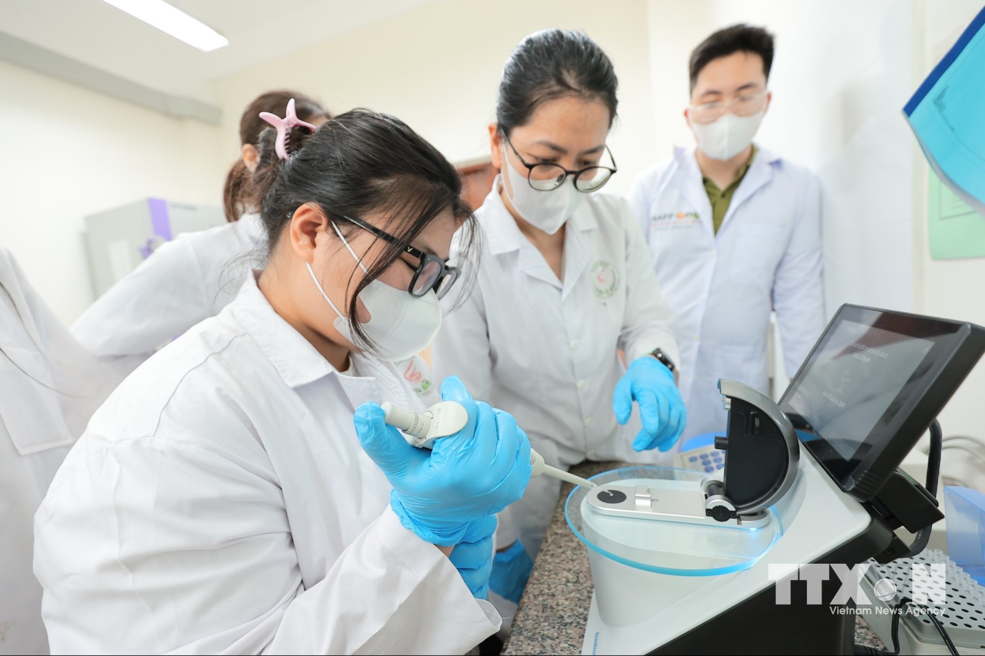Sinh viên Khoa Công nghệ sinh học thao tác đo nồng độ ADN thực vật sau tách chiết để phục vụ quá trình kiểm tra gien dưới sự chỉ dẫn của giảng viên. (Ảnh: Lê Đông/TTXVN)